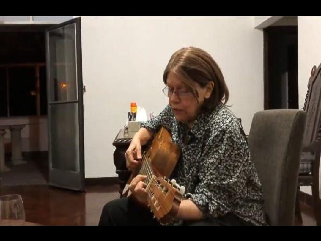 Ana Maria tocando violão e cantando